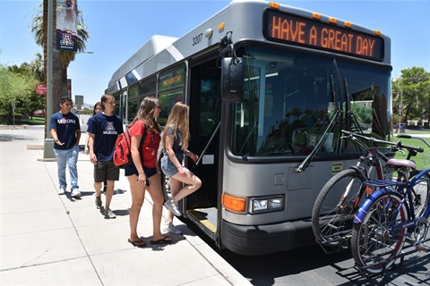 University of Arizona students wearing red and blue board a Sun Tran bus