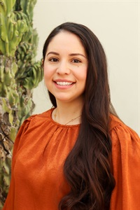 Brunette woman with long hair and orange shirt